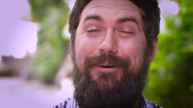 Sakallı bir adamın, rahatlığı ifade eden dev bir iç çekişi söndürme sinin portresi