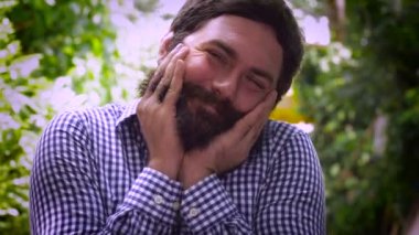 Sakalını dokunmaktan ve gülümseyen ve küçük öpücükler üfleme sakallı bir adam portresi