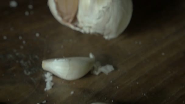 Dolly empuja los dientes de ajo enteros frescos sobre una mesa de madera — Vídeo de stock