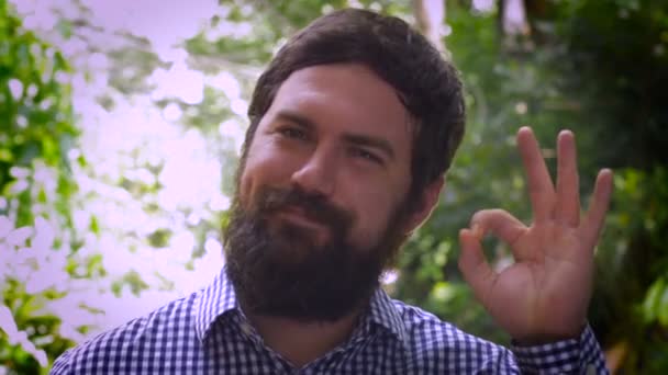 Portrait of a bearded man saying A OK with his left hand — Stock Video