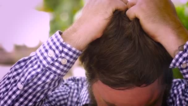 Retrato de un hombre barbudo arrancándose el pelo con asco y frustración — Vídeos de Stock