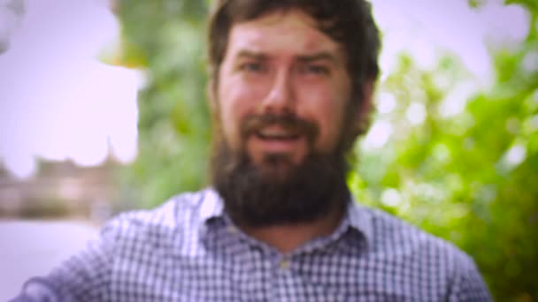 Rack focus portrait of a bearded man gives the thumbs down in disgust — Stock Video