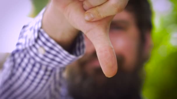 Extremo retrato de cerca de un hombre barbudo bajando los pulgares — Vídeos de Stock