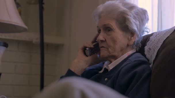 Una mujer de 90 años hablando y escuchando en un teléfono fijo inalámbrico en 4k — Vídeos de Stock