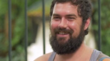 El atış sakallı bir adamın söz ve başını başını sallayarak dövmeler ile