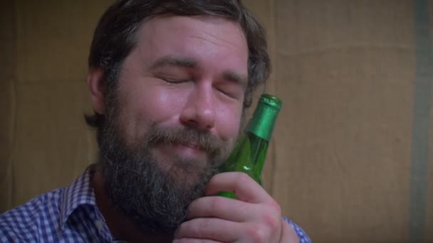 Gros plan d'un homme barbu qui aime sa bouteille de bière — Video