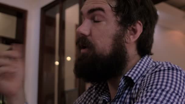 Un hipster con la barba piena ordina una birra, paga e beve qualcosa. — Video Stock