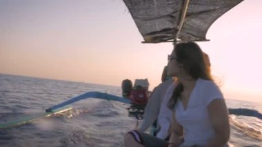 4 k görüntüleri üç turist üzerinde küçük bir motorlu tekne gündoğumu sırasında el