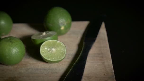 Continuous dolly limes on a wooden cutting board like still life — Stock Video