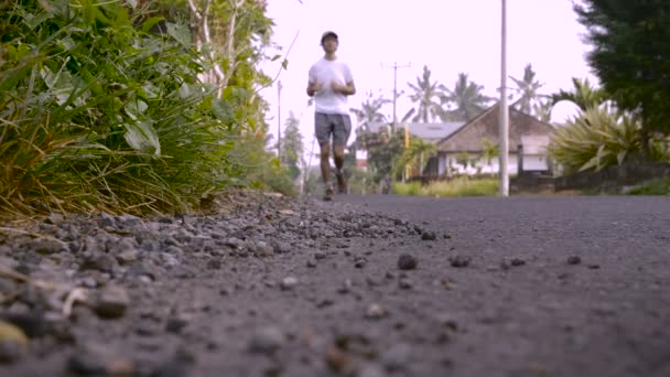 Ubud, Bali, Indonesien - ca oktober 2015 - Slow motion av en man som kör mot kameran som han kommer i fokus — Stockvideo