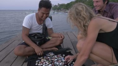 İki turist takı su üzerinde gece karanlığında bir dock üzerindeki bir satıcıdan satın