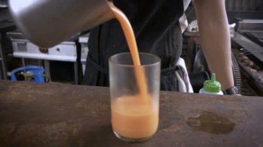 Bir şef bir portakal suyu serin bir bardak içine dökülen ve kameraya hizmet vermektedir