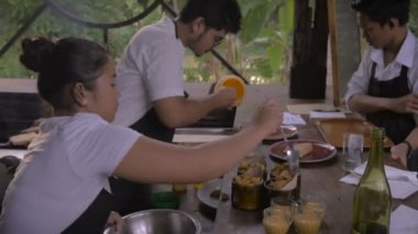 Bir garson bir açık hava restoranı, bir sipariş teyit ederken iki aşçılar yemek hazırlamak