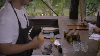 Yardımcı şef mezeler hazırlar ve bir kaba daldırma sos koyar
