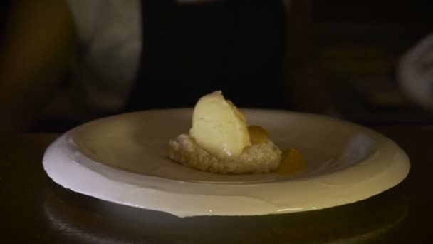 Een chef-kok legt de finishing touch op een dessert door druilerig saus uit de fles — Stockvideo