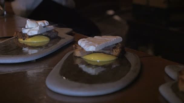 Dolly shot of a chef assembling three desserts — Stock Video