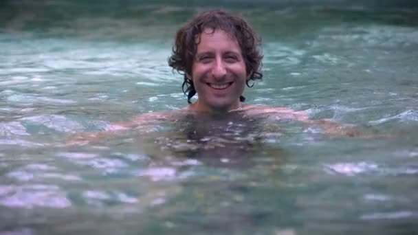 Portrait of a man smiling in a swimming pool in slow motion — Stock Video