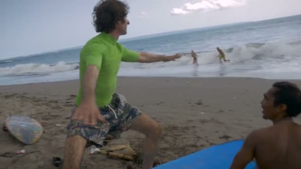 CANGGU, BALI, INDONESIA - CIRCA ENERO 2016 - Aprender a levantarse en una tabla de surf durante una lección de surf inicial — Vídeos de Stock