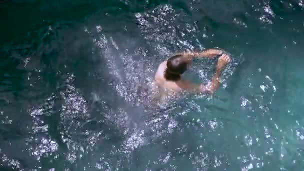 Slow motion overhead shot of a man swimming out of frame — Stock Video