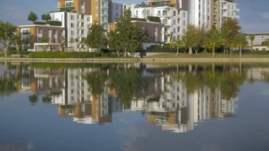 Pan bir lüks apartman kompleksi görüntüsünü oluşturma kadar bir gölde yansıyan