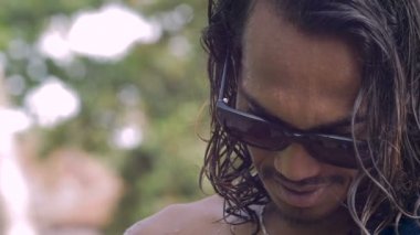 Bali dili delikanlı dalgalı saçlı kamera ve gülümsüyor görünüyor