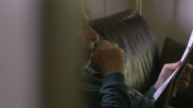 İyi görme ile sağlıklı bir kıdemli vurdu onun kanepe dolly bir gazete okur