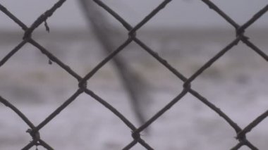 Sığ derinlik-in tarla bir zincir bağlantı çit üzerinden sert denizlerin kapatın