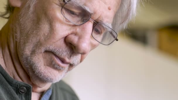 En man i hans 70-talet fyller sin veckovisa piller planner med sin medicin för veckan — Stockvideo