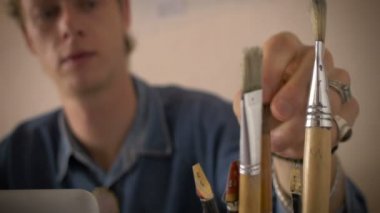 Genç bir sanatçı en son onun sanat projesi için bir boya fırçası seçer
