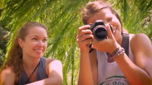 Portret van 2 jonge vrouwen glimlachend en het nemen van een foto naar de camera — Stockvideo