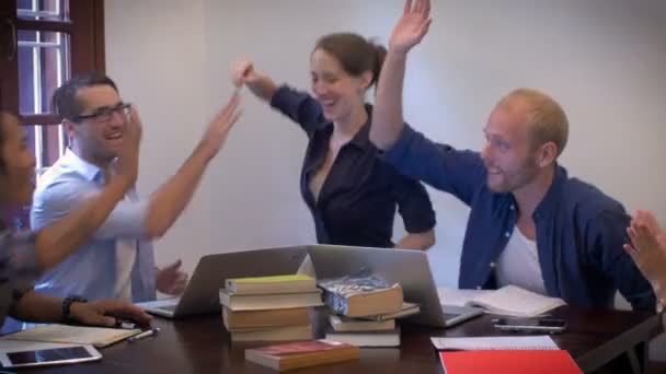 Un groupe mixte de jeunes professionnels occasionnels high five et poing bosse 