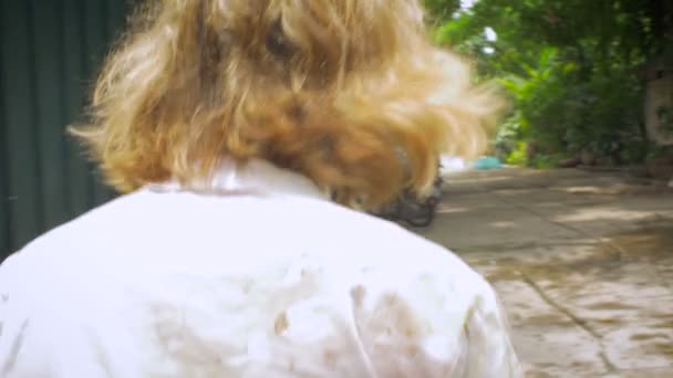 Kamera podąża młody blond kobieta jak podchodzi do kawiarni z tyłu — Wideo stockowe
