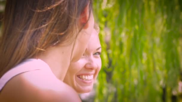 Twee vriendinnen hebben een intiem gesprek in een park - handheld — Stockvideo