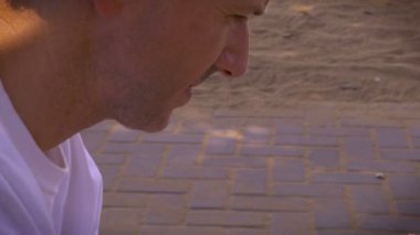 Adam akıllı mobil cep telefonu sahilde otururken kullanır