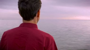 Kameraya dönüm ve sahilde gülümseyen orta yaşlı adam portresi