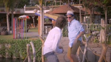 Ahşap bir köprüde birlikte eğleniyor iki orta yaşlı erkek arkadaş