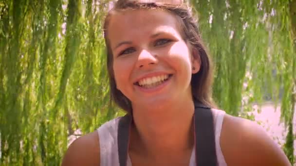 Jonge vrouwen in de 20 's kijkt naar de camera en neemt een foto terwijl glimlachen — Stockvideo