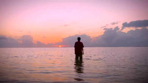 Ο άνθρωπος θέτει τα χέρια του σε μια στάση λατρείας στο ένα ήρεμο ωκεανό σε ένα surise πρωί — Αρχείο Βίντεο