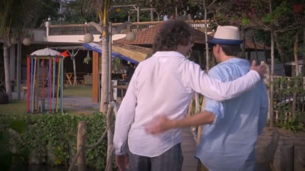 Slow mo of two middle aged male friends putting their arms around each other — Stock Video