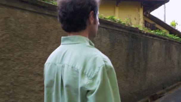 Steadicam arch skott av en ensam man går längs en bergvägg — Stockvideo