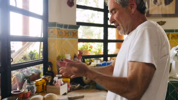 Profil d'un séduisant homme âgé travaillant une boule de pâte avec ses mains — Video