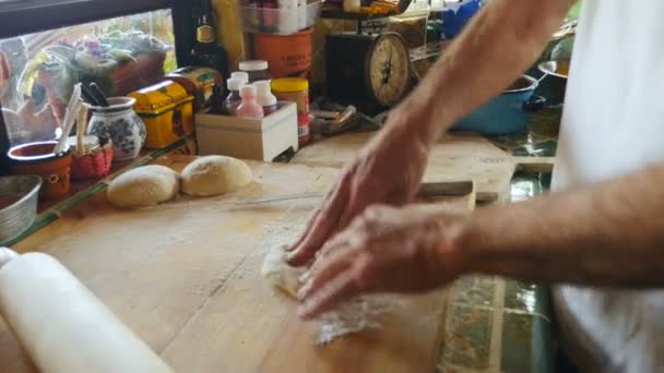 Hand held of an active senior male making pizza dough with his hands — Stock Video