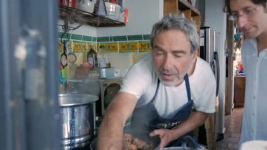 Yaşlı bir adam pişmiş tavuk ciğeri ve yumurta bir pot kaldırır