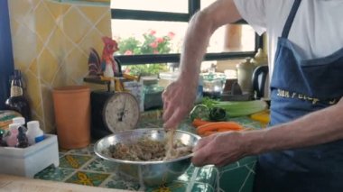 Baby boomer adam şiddetle ve heyecanla matzo topu bir kase karıştırma