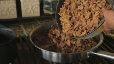 Bir adam yavaş çekimde bir ocak ta bir tavaya doğranmış karaciğer ekler