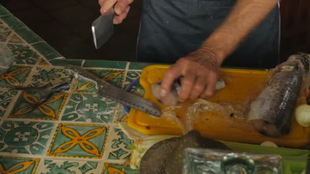 Un hombre guapo baby boomer utiliza una cuchilla para cortar pescado entero — Vídeos de Stock