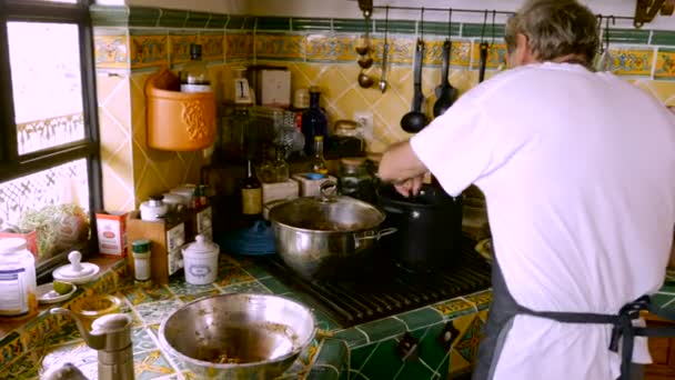 Um baby boomer judeu se diverte fazendo bolas de matzah caseiras ou bolas de carne — Vídeo de Stock