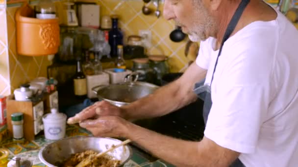 Een man in zijn 60s maakt zelfgemaakte maztah ballen met zijn handen — Stockvideo