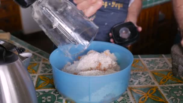 Взрослый мужчина наливает еду из блендера в пластиковую миску — стоковое видео