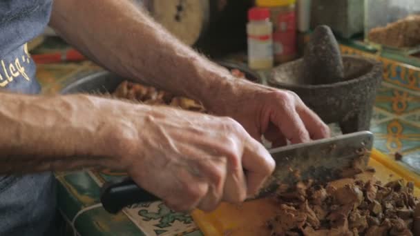 Un hombre usando una cuchilla de carne picando hígados de pollo cocidos en cámara lenta — Vídeos de Stock